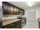 Updated kitchen featuring granite countertops and dark wood cabinets at 1172 Fernwood Dr, Holiday, FL 34690