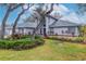 Gray house with landscaping and large trees in the front yard at 13012 Creek Manor Ct, Riverview, FL 33569