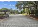 Gated community entrance with brick paved road at 13215 Slash Pine Dr # H, Hudson, FL 34669