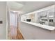 Hallway with kitchen pass-through and wood flooring at 13215 Slash Pine Dr # H, Hudson, FL 34669