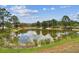 Serene pond view with lush greenery and clear reflections at 13215 Slash Pine Dr # H, Hudson, FL 34669