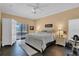 Main bedroom with dark hardwood floors, white bedroom furniture, and patio access at 13717 Pimberton Dr, Hudson, FL 34669