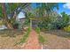 Charming bungalow with lush landscaping and brick walkway at 1402 E Mohawk Ave, Tampa, FL 33604