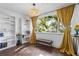 Sunlit living area featuring hardwood floors and yellow curtains at 1402 E Mohawk Ave, Tampa, FL 33604