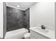 Modern bathroom with gray tile, white vanity, and bathtub at 177 Dowling Ne Ave, Port Charlotte, FL 33952
