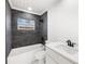 Updated bathroom features a dark tile shower and white vanity at 18434 Goodman Cir, Port Charlotte, FL 33948
