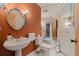 Elegant bathroom with orange walls, marble floors, and modern fixtures at 207 8Th E St, Tierra Verde, FL 33715