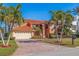 Two-story home with tile roof, large driveway, and palm trees at 207 8Th E St, Tierra Verde, FL 33715