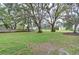 Spacious backyard perfect for outdoor activities, bordered by a wooden fence and large shade trees at 2131 Golden Oak Ln, Valrico, FL 33594