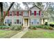 Tan two-story house with red shutters and a landscaped lawn at 2131 Golden Oak Ln, Valrico, FL 33594