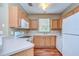 Galley kitchen with wood cabinets and white appliances at 2131 Golden Oak Ln, Valrico, FL 33594