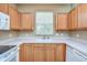 Kitchen with wood cabinets, white appliances, and a window at 2131 Golden Oak Ln, Valrico, FL 33594