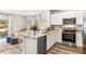 Stylish kitchen featuring white cabinets, marble countertops, stainless steel appliances, and adjacent living area at 2762 Pearly Banks Dr, Bradenton, FL 34208