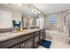 Double vanity bathroom with granite countertop and soaking tub at 30868 Kelmin Ter, Wesley Chapel, FL 33543