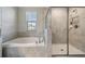 Bathroom with a walk-in shower and soaking tub at 30868 Kelmin Ter, Wesley Chapel, FL 33543