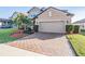 Two-story home with brick driveway and landscaping at 30868 Kelmin Ter, Wesley Chapel, FL 33543