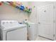Bright laundry room with washer, dryer, and ample shelving at 30868 Kelmin Ter, Wesley Chapel, FL 33543