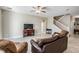 Living room with two leather couches, a staircase, and a large flat-screen TV at 30868 Kelmin Ter, Wesley Chapel, FL 33543