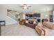 Spacious living room with tile floors, leather couches, and a view of the kitchen at 30868 Kelmin Ter, Wesley Chapel, FL 33543