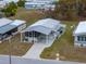 Aerial view of a mobile home with a carport and screened porch at 35921 Hermoso Ln, Zephyrhills, FL 33541