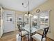 Cozy dining area with glass-top table and four chairs near a window at 35921 Hermoso Ln, Zephyrhills, FL 33541