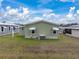 Rear view of house showing AC unit and lawn at 35921 Hermoso Ln, Zephyrhills, FL 33541