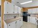 White kitchen cabinets, wood countertops, and black appliances at 35921 Hermoso Ln, Zephyrhills, FL 33541