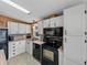 Modern kitchen with white cabinets, black appliances, and wood countertops at 35921 Hermoso Ln, Zephyrhills, FL 33541