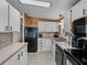 Kitchen boasts white cabinets, black appliances, and wood countertops at 35921 Hermoso Ln, Zephyrhills, FL 33541