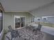 Relaxing screened porch with patio furniture and area rug at 35921 Hermoso Ln, Zephyrhills, FL 33541