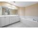 Bathroom with double vanity, soaking tub, and tile floors at 425 150Th Ave # 2401, Madeira Beach, FL 33708