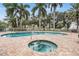 Community pool and hot tub with lounge chairs at 425 150Th Ave # 2401, Madeira Beach, FL 33708