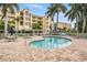 Community pool with patio furniture and nearby building at 425 150Th Ave # 2401, Madeira Beach, FL 33708