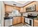 Well-lit kitchen featuring wooden cabinets, granite countertops, and stainless steel appliances at 601 N Hercules Ave # 1003, Clearwater, FL 33765