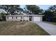 Gray house with a white garage door and a spacious lawn at 611 Pinewood Dr, Dunedin, FL 34698