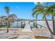 Private boat dock on a calm waterway with palm trees at 65 Dolphin Dr, Treasure Island, FL 33706