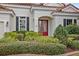 Red double doors with glass inserts and manicured landscaping at 11910 Climbing Fern Ave, Riverview, FL 33579