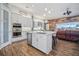 Open kitchen with island, stainless steel appliances, and wood-look tile floors at 11910 Climbing Fern Ave, Riverview, FL 33579