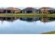 Calm lake reflecting houses with a clear sky at 11910 Climbing Fern Ave, Riverview, FL 33579