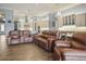 Spacious living room with brown leather reclining sofas at 11910 Climbing Fern Ave, Riverview, FL 33579