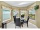 Cozy breakfast nook with a glass-top table and four chairs, overlooking the backyard at 1215 Dustan Pl, Trinity, FL 34655
