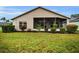 House back view, screened patio, well-manicured lawn, and lush landscaping at 1215 Dustan Pl, Trinity, FL 34655