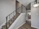 Modern staircase with a metal railing and wood-look floors at 12430 81St Pl, Seminole, FL 33772