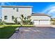 Rear view of the house showing the two-car garage, landscaping, and patio area at 1308 Alhambra Dr, Apollo Beach, FL 33572