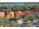 Aerial view of community showcasing homes with tile roofs and a lake at 14608 Mirasol Manor Ct, Tampa, FL 33626