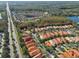 Aerial view of community, showing numerous homes near a main road and lake at 14608 Mirasol Manor Ct, Tampa, FL 33626