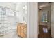 Clean bathroom with shower/tub combo, wood vanity, and linen closet at 14608 Mirasol Manor Ct, Tampa, FL 33626