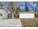 White shed and a large backyard with mature trees and a concrete patio at 1575 S Martin Luther King Jr Ave, Clearwater, FL 33756