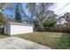 White shed and a large backyard with mature trees and a concrete patio at 1575 S Martin Luther King Jr Ave, Clearwater, FL 33756