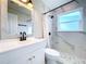 Updated bathroom featuring a white vanity, marble shower, and a stylish mirror at 1709 Marilyn Ave, Bradenton, FL 34207
